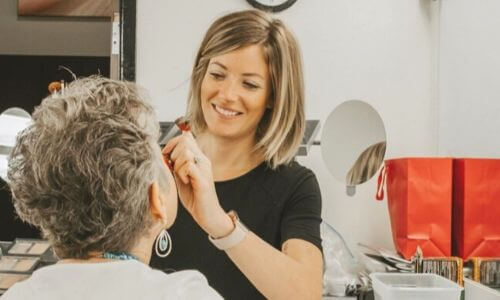 A woman applying makeup on someone.