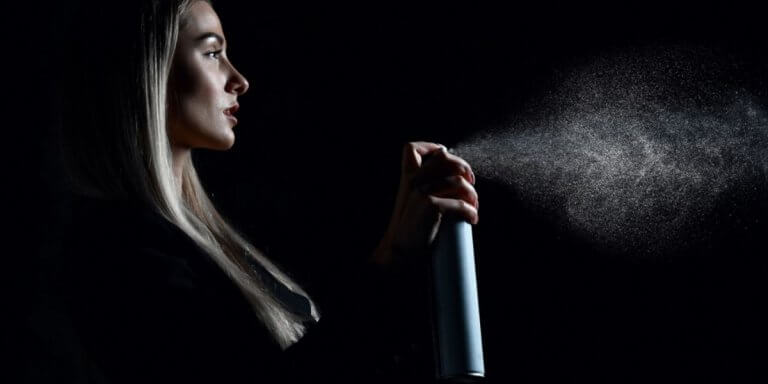 woman spraying hair spray