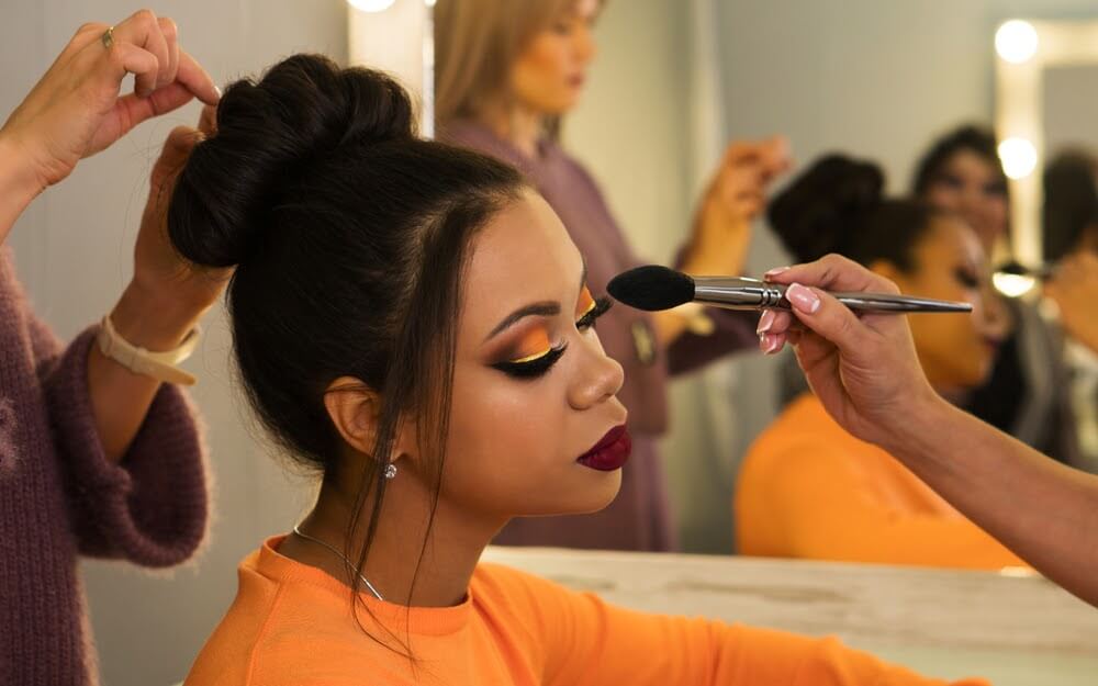 Woman having makeup applied.
